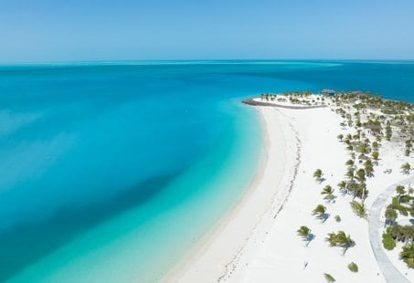 A pristine white sand beach with turquoise waters and palm trees | MSC Cruises A pristine white sand beach with turquoise waters and palm trees | MSC Cruises