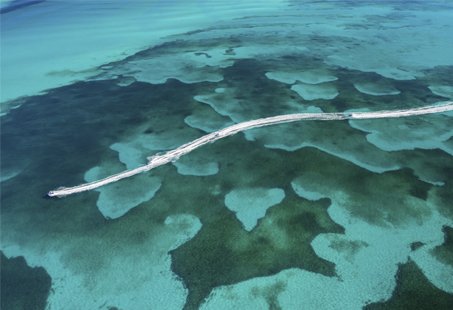 A long jetty stretching over turquoise waters and coral reefs | MSC Cruises