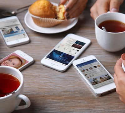 Smartphones on a table showing MSC Cruises apps and social media, with tea and muffins | MSC Cruises Smartphones on a table showing MSC Cruises apps and social media, with tea and muffins | MSC Cruises