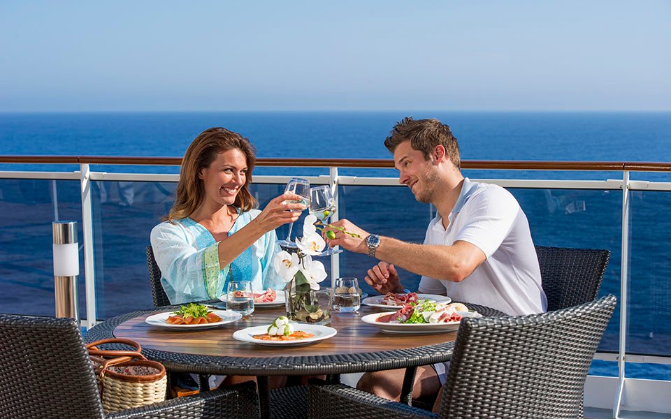 Couple enjoying a romantic meal on a cruise ship balcony with ocean views | MSC Cruises Couple enjoying a romantic meal on a cruise ship balcony with ocean views | MSC Cruises