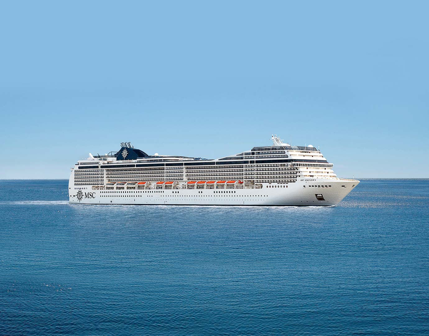 An MSC cruise ship sailing on calm blue waters under a clear sky | MSC Cruises An MSC cruise ship sailing on calm blue waters under a clear sky | MSC Cruises